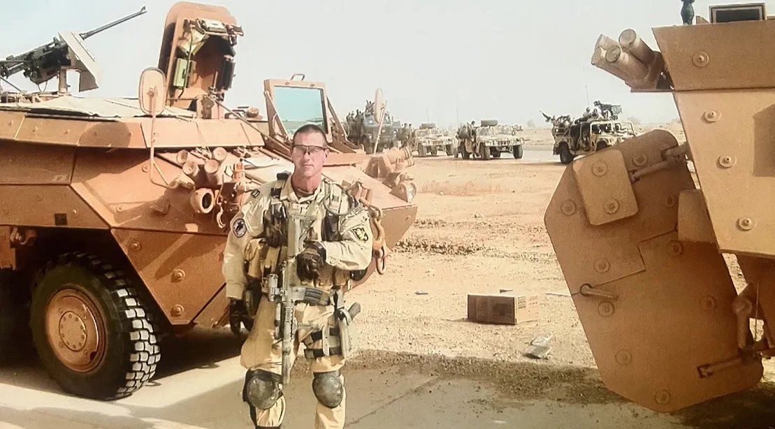 SEAC David Isom in the desert surrounded by armored vehicles