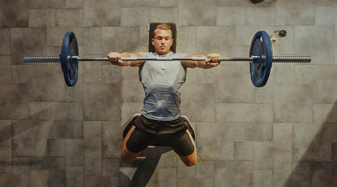 Top view of a fit athletic man performing a bench press exercise using a proper bench press setup