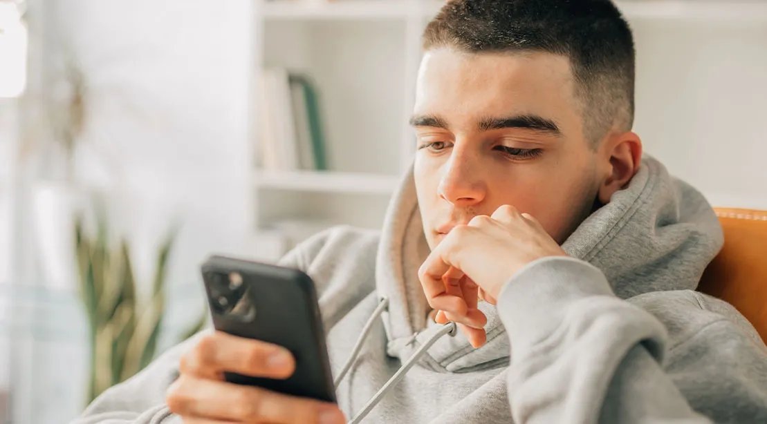 Young teenage boy on social media apps on his phone