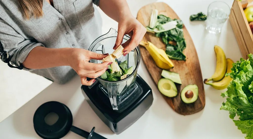 Female making a smoothie using bananas